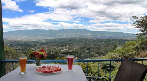 a table with two glasses of beer and a plate of fruit at Suites Arcoiris in Villa de Leyva