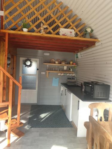 a kitchen with a counter top and a staircase at Sallys Cabin in Kilcolgan
