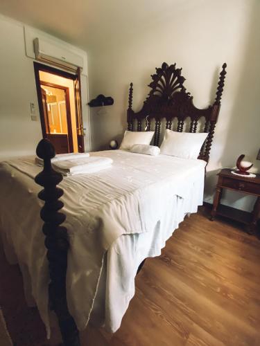 a bedroom with a large bed with a wooden headboard at Casa da Tanquinha in Beiral do Lima