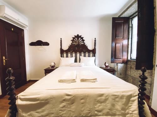 a bedroom with a large bed with a wooden headboard at Casa da Tanquinha in Beiral do Lima