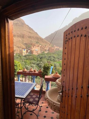 a balcony with a table and a view of a mountain at Riad Sephora in Tinerhir