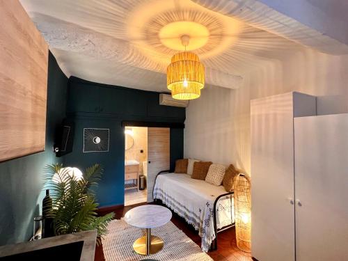 une chambre avec un lit et un lustre dans l'établissement CALANQUE DE PORT PIN, à Cassis
