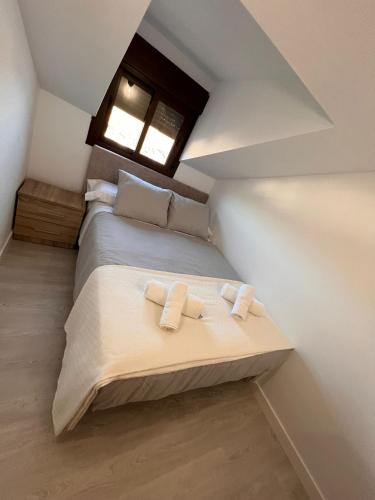 a bedroom with a bed with two towels on it at ATICO BUENAVISTA in Ardales