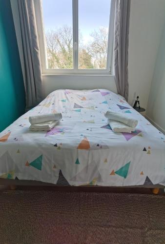 1 cama en un dormitorio con ventana en Quatre Moulins - 3 chambres - WIFI - Refait à neuf en Brest
