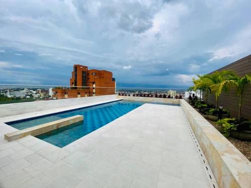 een zwembad op het dak van een gebouw bij Apartamento en Granada con piscina, turco, estacionamiento in Cali