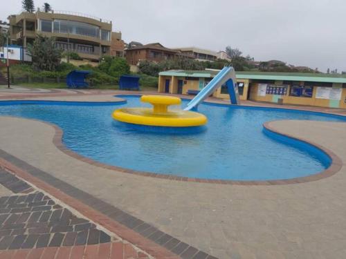 a swimming pool with a slide in a playground at Oceans Breeze - Unit 2 Second floor in Durban