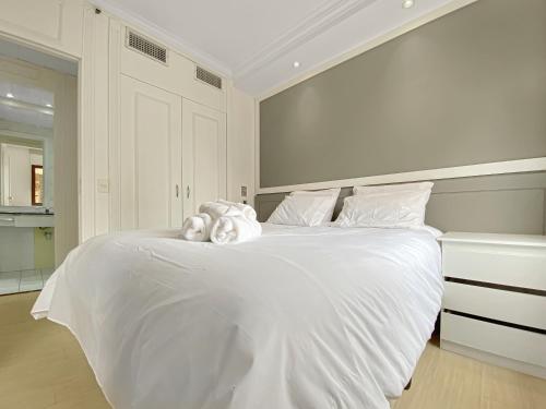 1 dormitorio blanco con 1 cama grande con sábanas blancas en Hotel deslumbrante na Vila Olimpia, en São Paulo
