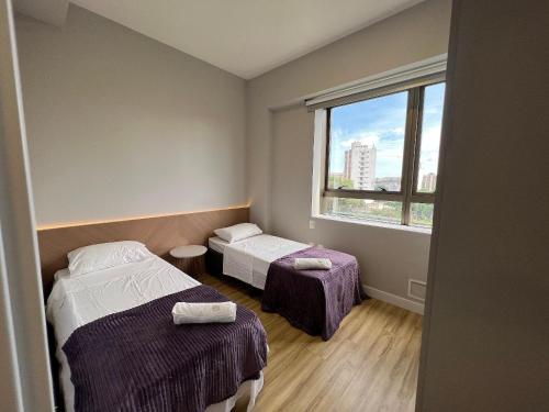 um pequeno quarto com 2 camas e uma janela em Locking's Santo Agostinho 4 em Belo Horizonte