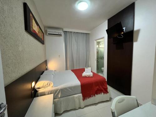 Habitación de hotel con cama con manta roja en Pousada Aquarela Do Brasil, en Maceió