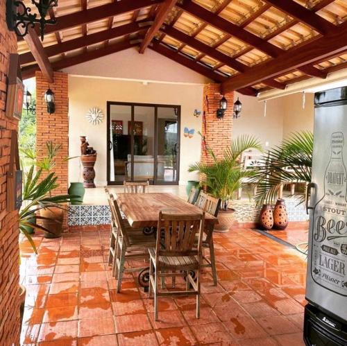 an outdoor patio with a wooden table and chairs at Magia da Serra Casa Temporada in Pirenópolis