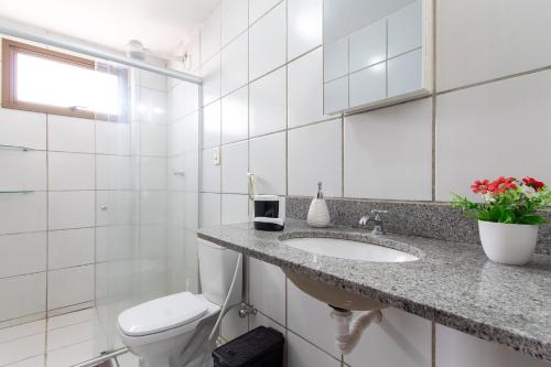 een witte badkamer met een wastafel en een toilet bij Residencial Califórnia em Lagoa Nova por Carpediem in Natal