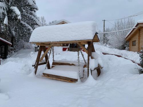 a gazebo covered in snow in a yard at Cabanele Sașilor in Cisnadioara