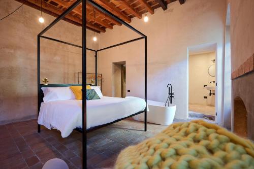 a bedroom with a bed and a tub in a room at Domus Dea Luxury in Bergamo