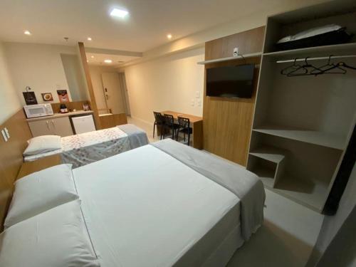 ein Hotelzimmer mit einem Bett und einem Esszimmer in der Unterkunft Quarto para 4 pessoas in Campos dos Goytacazes