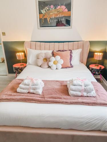 a bed with two towels and flowers on it at Dawns House Cromford, Peak District, Hot Tub, for 6 - stunning views in Cromford