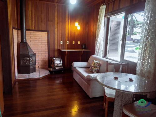 a living room with a couch and a wood stove at Morada Das Araucárias in São Francisco de Paula