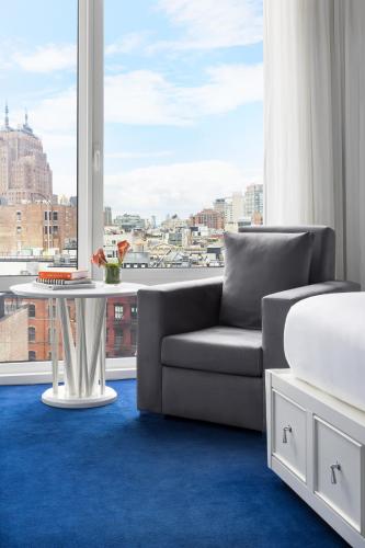 a living room with a couch and a table and a window at NoMo SoHo in New York