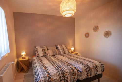 a bedroom with a bed and a chandelier at Maison à 800m de la plage in Saint-Lunaire