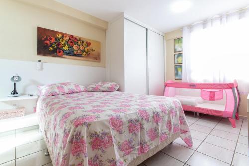 1 dormitorio con 1 cama con colcha rosa en Conde da Praia #501 Conforto em Natal by Carpediem, en Natal