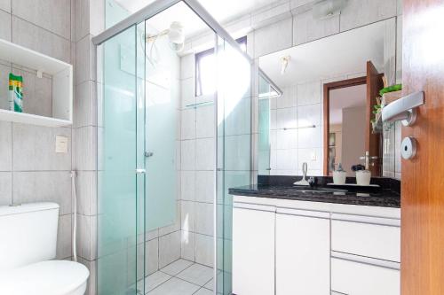uma casa de banho com uma cabina de duche em vidro e um WC. em Conde da Praia #501 Conforto em Natal by Carpediem em Natal