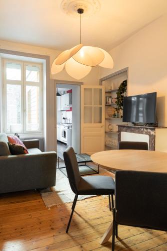 un salon avec une table et un canapé dans l'établissement Appart chaleureux face gare, à Limoges