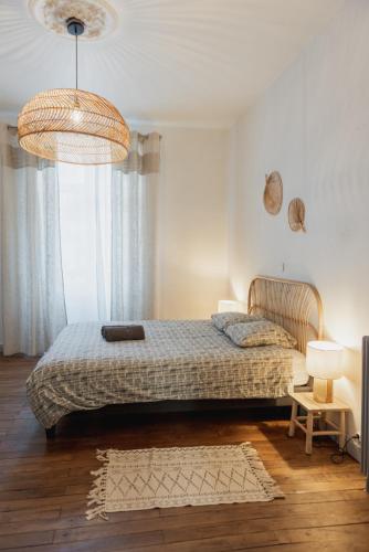 une chambre avec un lit et une grande fenêtre dans l'établissement Appart chaleureux face gare, à Limoges