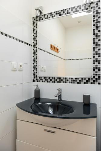 une salle de bain avec un lavabo et un miroir dans l'établissement Appart chaleureux face gare, à Limoges