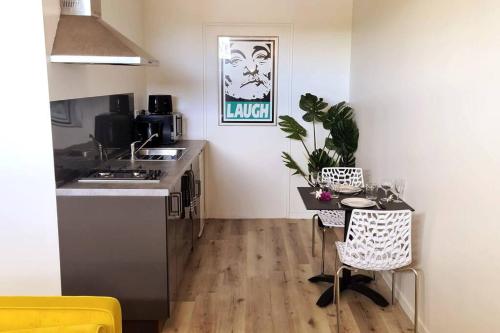 a kitchen with a sink and a table in a room at Studio Ninirei in Papeete