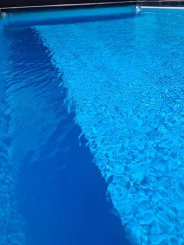 a blue swimming pool with blue water at Studio Ninirei in Papeete