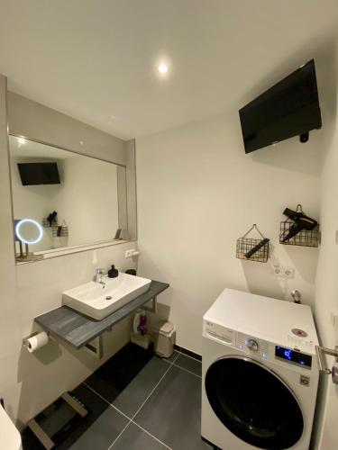 a bathroom with a sink and a washing machine at Modernes Apartment in zentraler Lage in Chemnitz