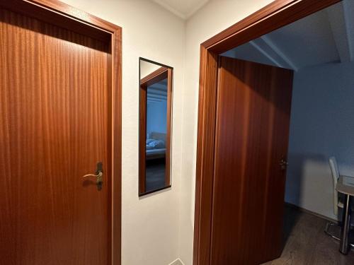 une porte menant à une chambre avec un miroir dans l'établissement Ferienwohnung zum Winterberg, à Elsterwerda