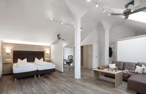 ein Wohnzimmer mit einem Bett und einem Sofa in der Unterkunft Wirtshaus & Hotel Goldener Greif in Edelsfeld