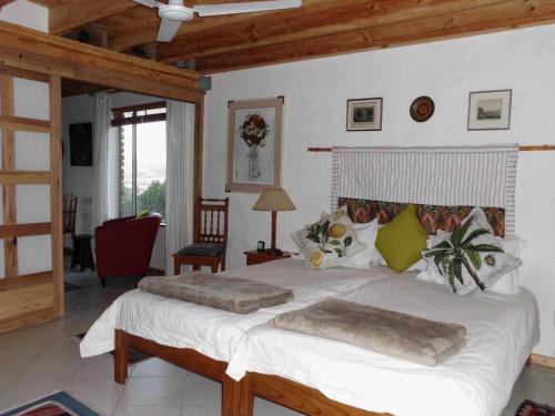 sypialnia z dużym białym łóżkiem w pokoju w obiekcie Guinea Fowl Loft w mieście Knysna
