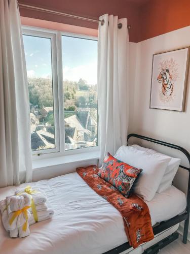 a bed in a room with a large window at Dawns House Cromford, Peak District, Hot Tub, for 6 - stunning views in Cromford