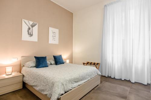 ナポリにあるSanta Lucia Homeのベッドルーム1室(青い枕のベッド1台、窓付)
