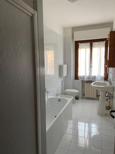 a white bathroom with a tub and a sink at Casa di Lea in Bibbiena