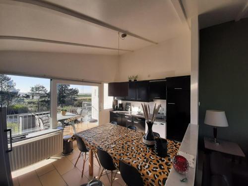 een keuken met een tafel met stoelen en een groot raam bij Ostrea 14 Roompot beach resort Kamperland in Kamperland
