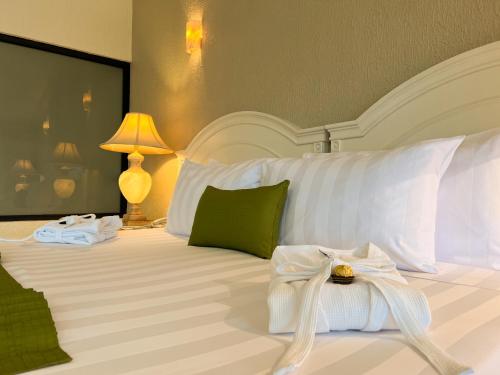 a bedroom with a white bed with a bow on it at Excelaris Grand Resort Conventions & Spa in Tequesquitengo