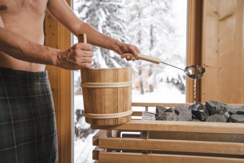 a man is stirring a pot with a spoon at Evident Hotel Prägant in Bad Kleinkirchheim