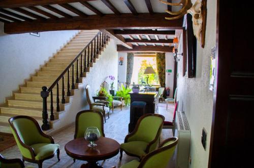 Zimmer mit einer Treppe mit Stühlen und einem Tisch in der Unterkunft Hôtel Grand-Champ in Malmedy