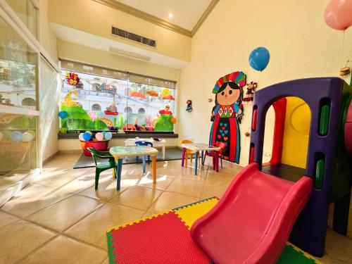a childrens room with a play room with a table and chairs at Excelaris Grand Resort Conventions & Spa in Tequesquitengo