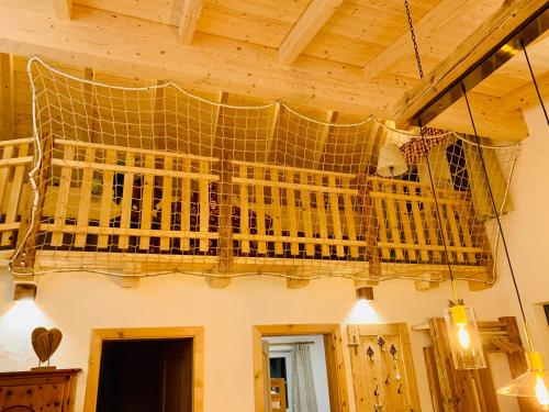 a bird cage hanging from the ceiling of a room at Bergheimat in Bad Goisern