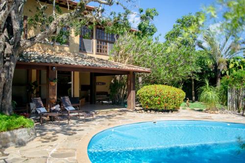 a swimming pool in front of a house at Pousada da Cyssa in Búzios