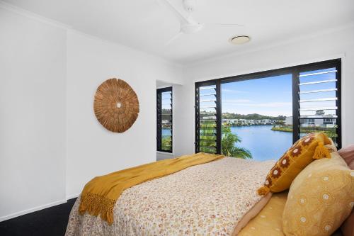 a bedroom with a bed and a large window at Executive, modern waterfront house in Maroochydore