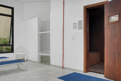 Habitación con puerta, silla y alfombra azul en Hotel com piscina e academia na Gomes de Carvalho, en São Paulo