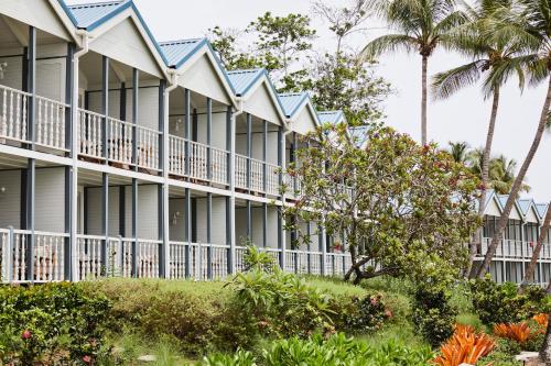 a row of houses with balconies and palm trees at Soho Beach House Canouan in Canouan