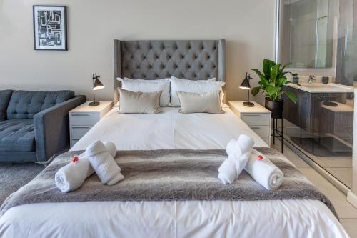 a bedroom with a large bed with towels on it at Menlyn Maine - The Trilogy Apartment 1111 in Pretoria