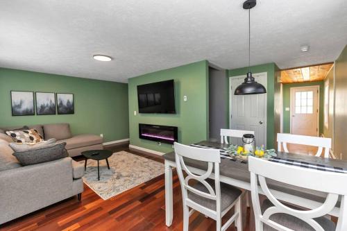 a living room with green walls and a table and chairs at *NEW* Beautiful 3 floor Townhome with Sauna in Manchester