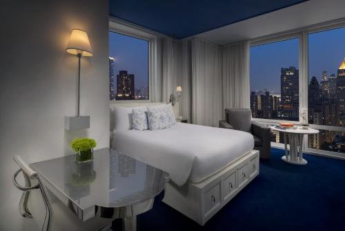 a hotel room with a bed and a desk and a window at NoMo SoHo in New York