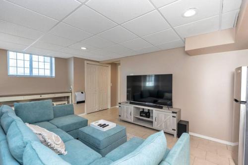 a living room with a blue couch and a flat screen tv at *NEW* Beautiful 3 floor Townhome with Sauna in Manchester